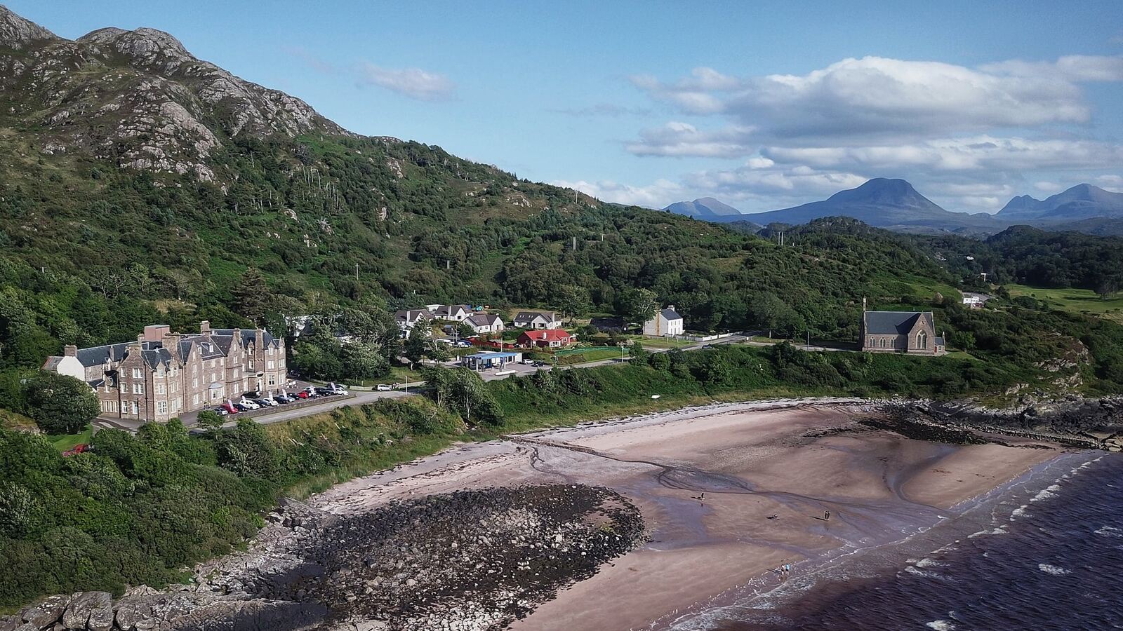 The Gairloch Hotel from the air, above the beach on Gairloch Bay with the Torridon hills behind